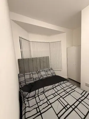 a bedroom with a bed in a white room at Stylish Dream Home with 4 en-suite Bedrooms in Liverpool