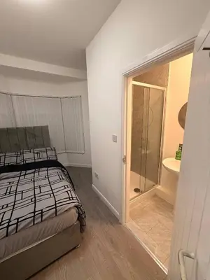 a bedroom with a bed and a bathroom with a shower at Stylish Dream Home with 4 en-suite Bedrooms in Liverpool