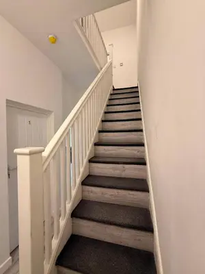 a staircase in a home with white railings at Stylish Dream Home with 4 en-suite Bedrooms in Liverpool