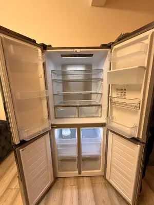 an empty refrigerator with its doors open in a kitchen at Stylish Dream Home with 4 en-suite Bedrooms in Liverpool