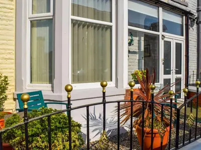 a porch with a fence and a potted plant at Contractor's Rest in Blackpool