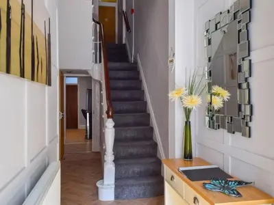 a staircase in a home with a vase of flowers at Contractor's Rest in Blackpool