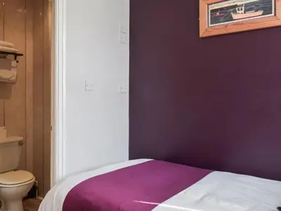 a purple bedroom with a bed and a toilet at Contractor's Rest in Blackpool