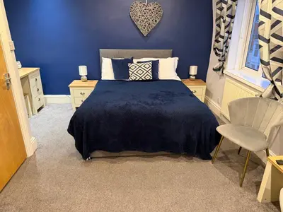 a blue bedroom with a bed and a chair at Contractor's Rest in Blackpool