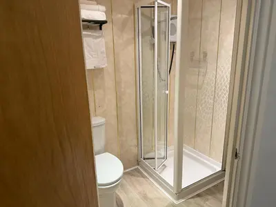 a bathroom with a toilet and a glass shower at Contractor's Rest in Blackpool