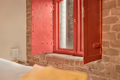 a red window on the side of a brick wall at GuestReady - Cozy retreat in vibrant Liverpool in Liverpool
