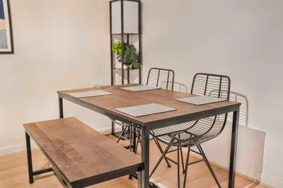 a wooden table with two chairs and a plant at GuestReady - Cozy retreat in vibrant Liverpool in Liverpool