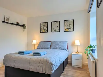 a bedroom with a bed with blue sheets and two lamps at Guest Rooms Near Centre & Anfield Free Parking in Liverpool