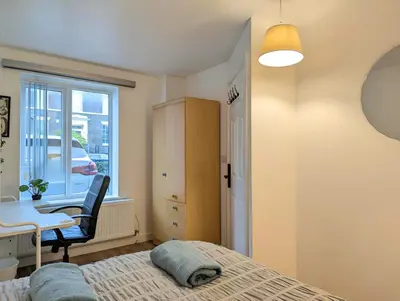 a bedroom with a bed and a desk and a window at Guest Rooms Near Centre & Anfield Free Parking in Liverpool