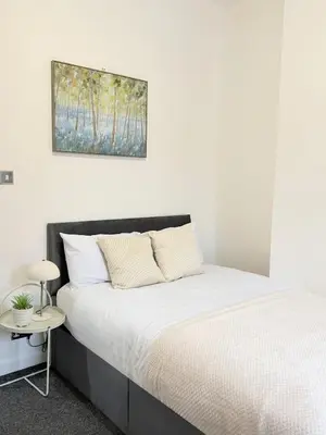a bedroom with a bed and a picture on the wall at Deepdale House - Comfortable 2 Bedroom Home near Major Attractions in Preston in Preston