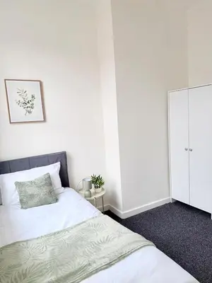 a white bedroom with two beds and a cabinet at Deepdale House - Comfortable 2 Bedroom Home near Major Attractions in Preston in Preston