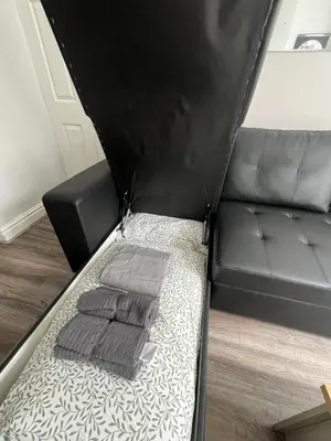 a bed with two pillows on it with a couch at Spacious Home From Home, Parking, Contractors in Liverpool