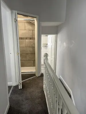 a hallway with a stairway leading to a door at Spacious Home From Home, Parking, Contractors in Liverpool