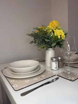 a table with plates and a vase with yellow flowers at City-Close Studio By Escape & Estates Short Lets & Serviced Accommodation Liverpool with Free parking and Wifi in Liverpool
