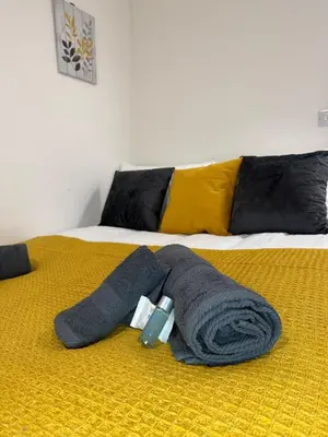 a bed with a blanket and a towel and a cup on it at City-Close Studio By Escape & Estates Short Lets & Serviced Accommodation Liverpool with Free parking and Wifi in Liverpool
