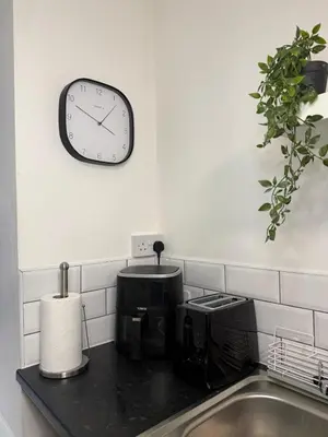 a clock on a wall above a kitchen sink at City-Close Studio By Escape & Estates Short Lets & Serviced Accommodation Liverpool with Free parking and Wifi in Liverpool
