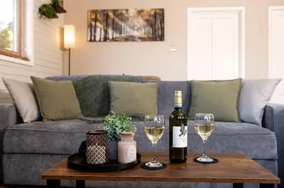 a bottle of wine and two glasses on a table at Swanmere lodge, Lakeside view Pinelake Carnforth in Carnforth