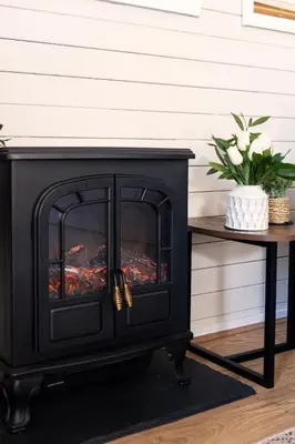 a fireplace in a living room next to a table at Swanmere lodge, Lakeside view Pinelake Carnforth in Carnforth