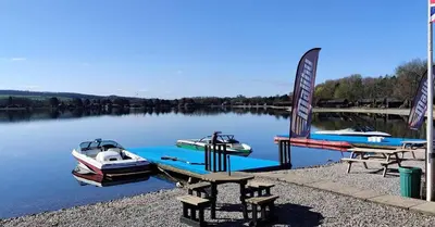 two boats are docked at a dock on a lake at Swanmere lodge, Lakeside view Pinelake Carnforth in Carnforth