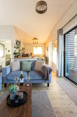 a living room with a blue couch and a table at Swanmere lodge, Lakeside view Pinelake Carnforth in Carnforth