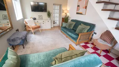 a living room with a green couch and chairs at Welcoming 3 bed home in Formby