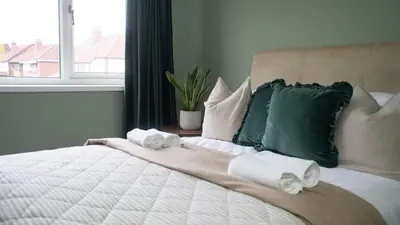 a bedroom with a large bed with towels on it at Welcoming 3 bed home in Formby
