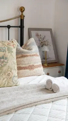 a bed with a pile of towels on it at Welcoming 3 bed home in Formby