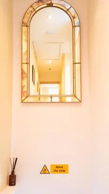a mirror on a wall above a sink in a bathroom at Welcoming 3 bed home in Formby