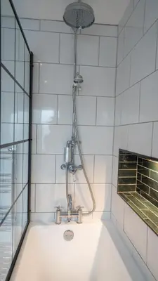 a bathroom with a bath tub with a shower at Welcoming 3 bed home in Formby