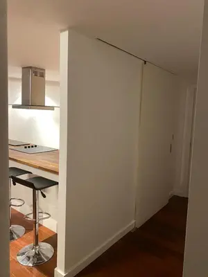 a room with a white wall next to a table at Entire Pent House In Down Town Liverpool in Liverpool