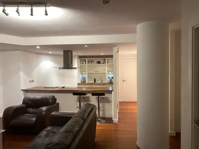 a living room with a couch and a kitchen at Entire Pent House In Down Town Liverpool in Liverpool