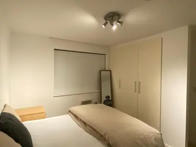 a bedroom with a bed and a white cabinet at Entire Pent House In Down Town Liverpool in Liverpool