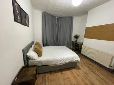 a bedroom with a bed and a desk in a room at Liverpool 4-Bed Home, Free Parking in Liverpool