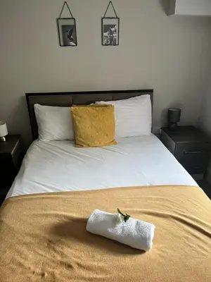 a bed with a white towel on top of it at The Works Apartments in Liverpool