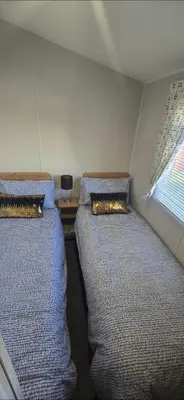 two beds in a small room with a window at Graham's Dream in Heysham