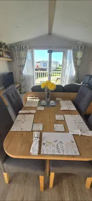 a wooden table with flowers and cards on it at Graham's Dream in Heysham