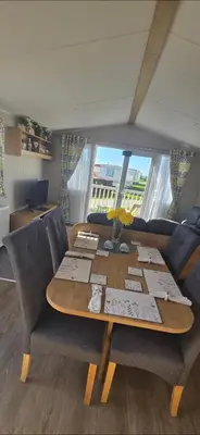 a dining room table with chairs and a couch at Graham's Dream in Heysham