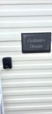 a sign on the side of a white wall at Graham's Dream in Heysham
