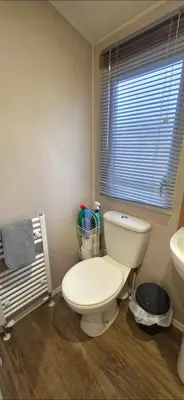 a bathroom with a toilet and a sink and a window at Graham's Dream in Heysham