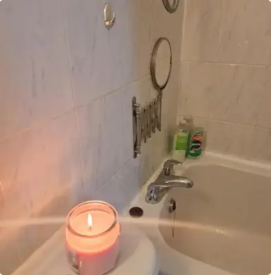 a candle sitting on top of a sink next to a bath tub at Spacious 2BR, 5 Min Walk to Anfield, Free Parking in Liverpool