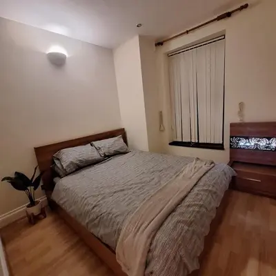 a bedroom with a large bed and a window at Spacious 2BR, 5 Min Walk to Anfield, Free Parking in Liverpool