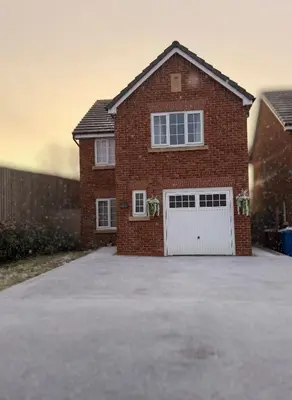a red brick house with a white garage at Spring gardens in Lower Darwen