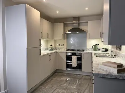 a kitchen with white cabinets and a stove top oven at Spring gardens in Lower Darwen