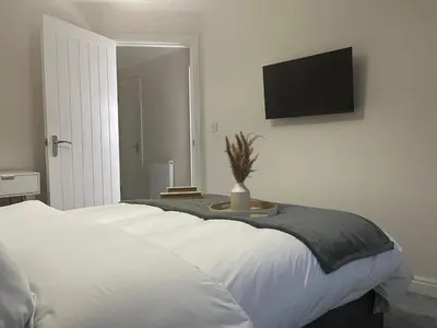 a bedroom with a bed with a tv on the wall at Spring gardens in Lower Darwen