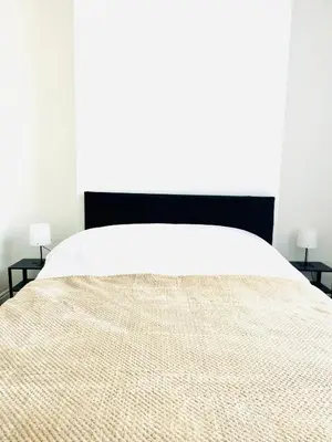 a bedroom with a large bed and two night stands at Clovelly Road, Anfield LFC in Liverpool