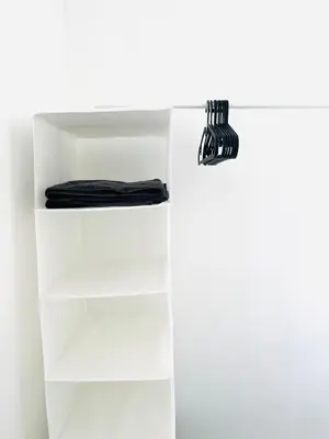 a white book shelf with a black object on it at Clovelly Road, Anfield LFC in Liverpool
