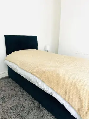 a bedroom with a large bed with a black headboard at Clovelly Road, Anfield LFC in Liverpool