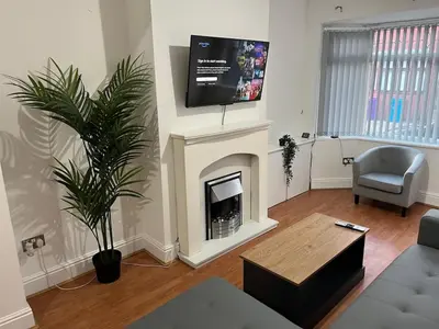 a living room with a fireplace with a tv above it at 3BR Home, Parking, Families, Contractors, Wi-Fi in Liverpool
