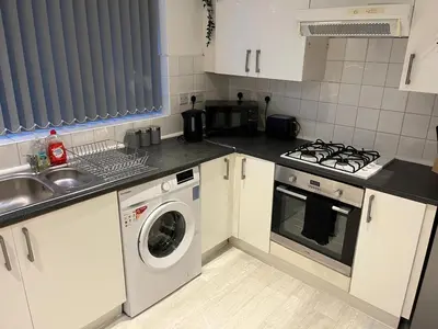 a kitchen with a sink and a washing machine at 3BR Home, Parking, Families, Contractors, Wi-Fi in Liverpool