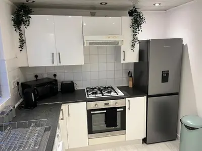 a kitchen with white cabinets and a black refrigerator at 3BR Home, Parking, Families, Contractors, Wi-Fi in Liverpool